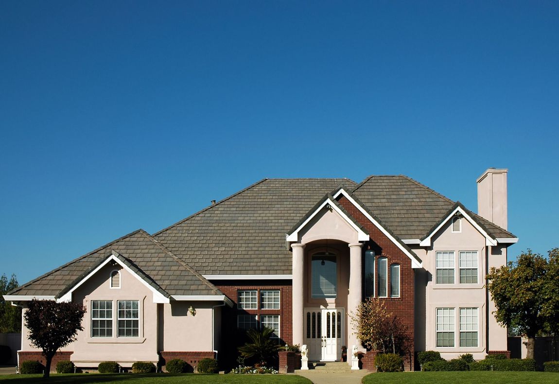 A large, two-story house with a light pink exterior
