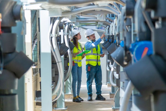 A man and a woman are working in a factory.