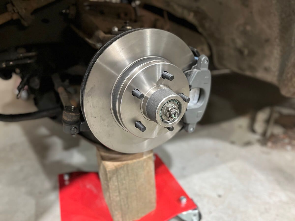 A brake disc is sitting on top of a wooden block.