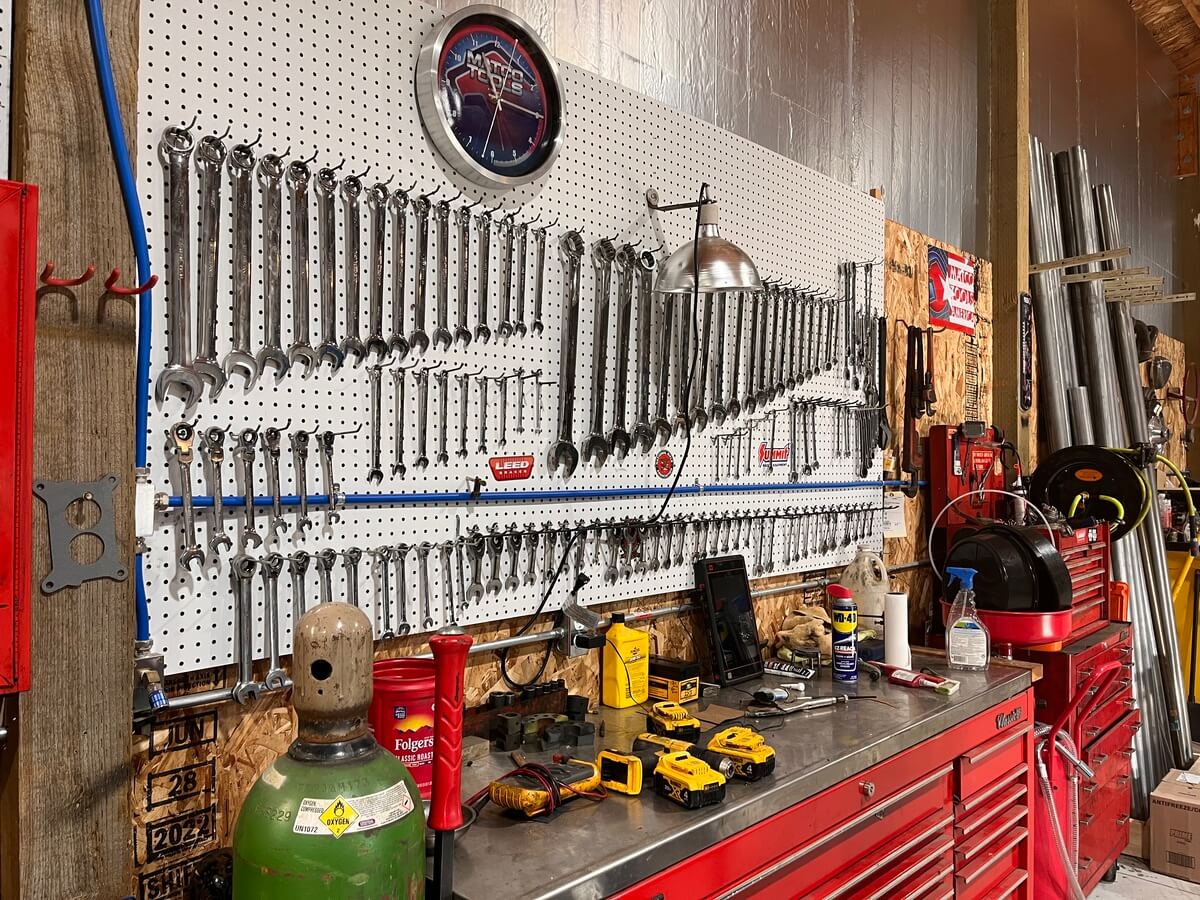 There are a lot of tools hanging on the wall in the garage.