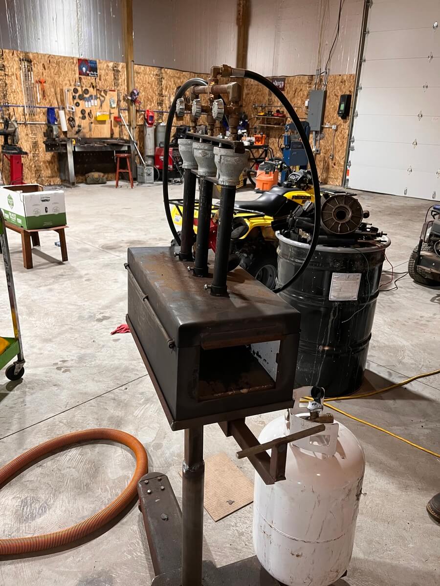 A machine is sitting in a garage next to a barrel.