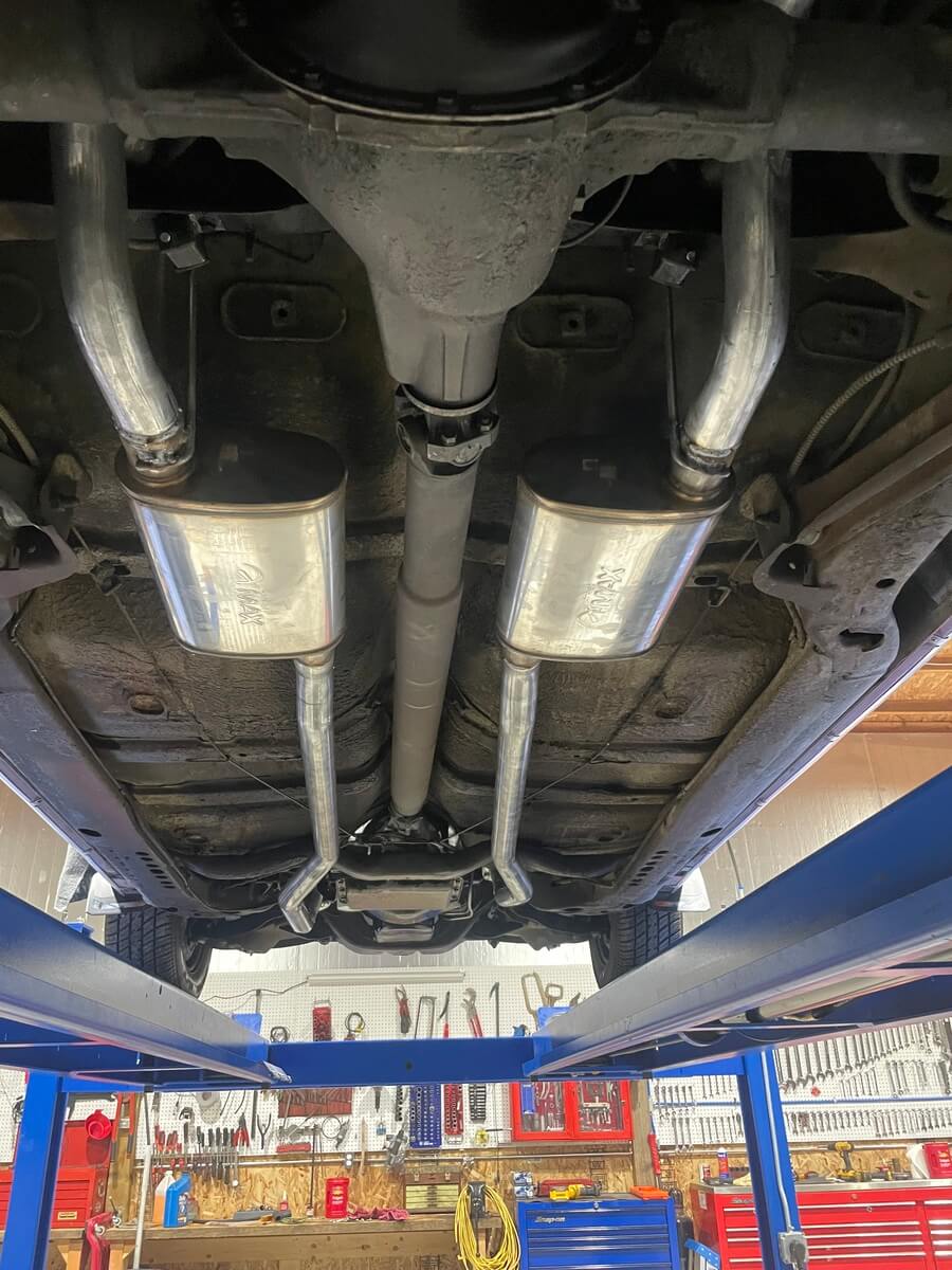 A car is sitting on a lift in a garage.