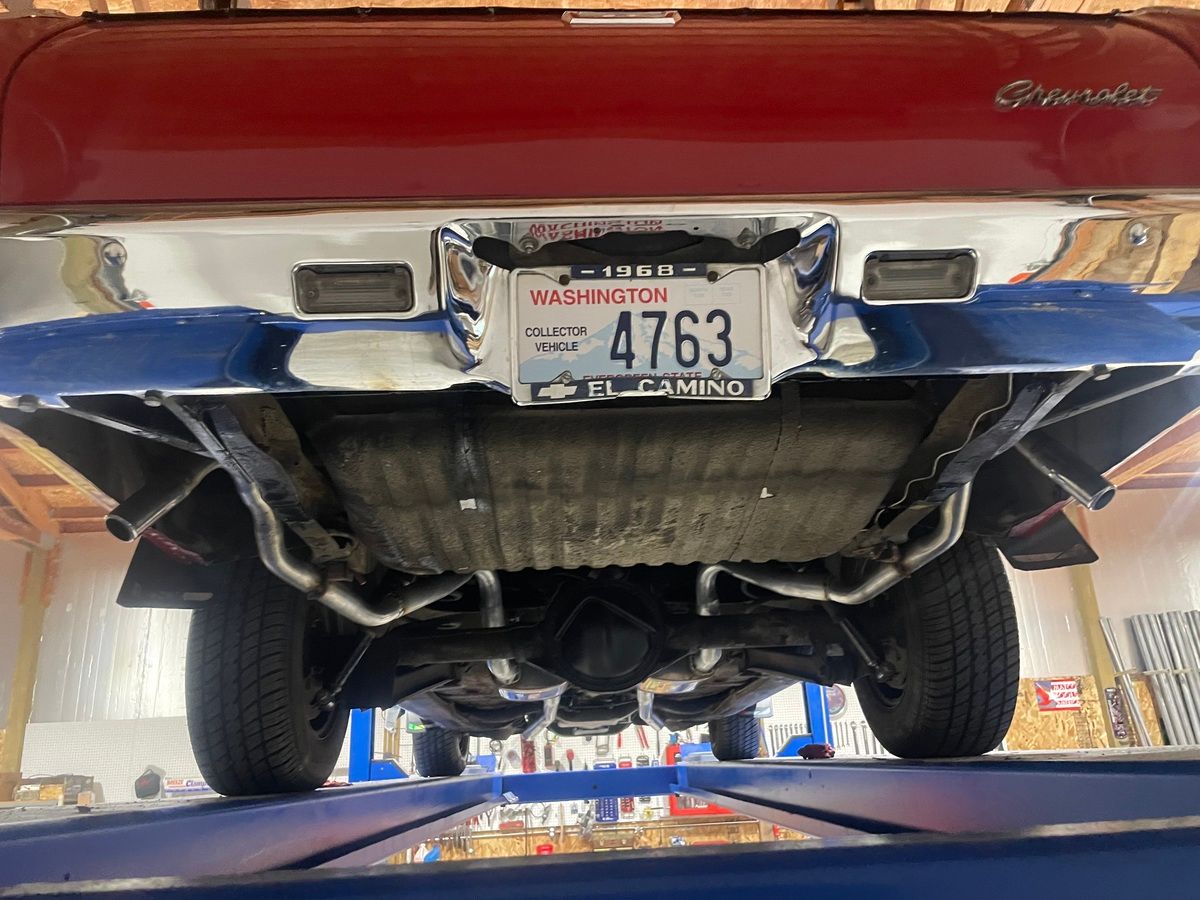 A red car with a license plate that says 4763 is parked in a garage.