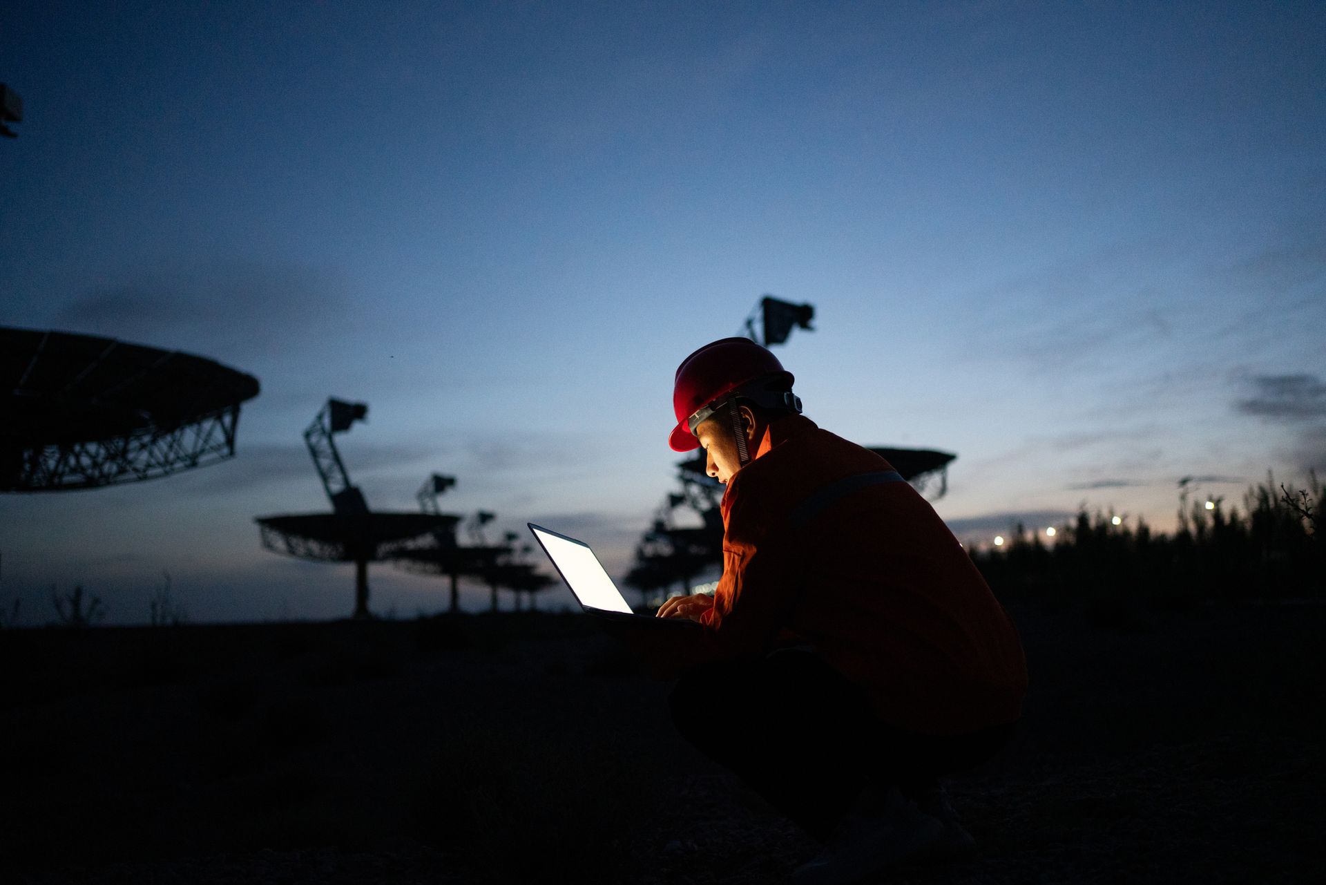 Engineer in hard hat working with laptop.