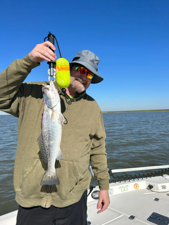 A man on a boat holding a fish in his hand