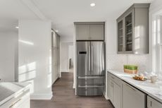 A kitchen with stainless steel appliances and gray cabinets.