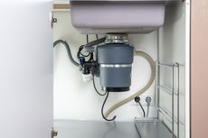 A kitchen sink with a garbage disposal underneath it.