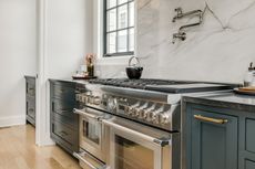 A kitchen with stainless steel appliances and blue cabinets.