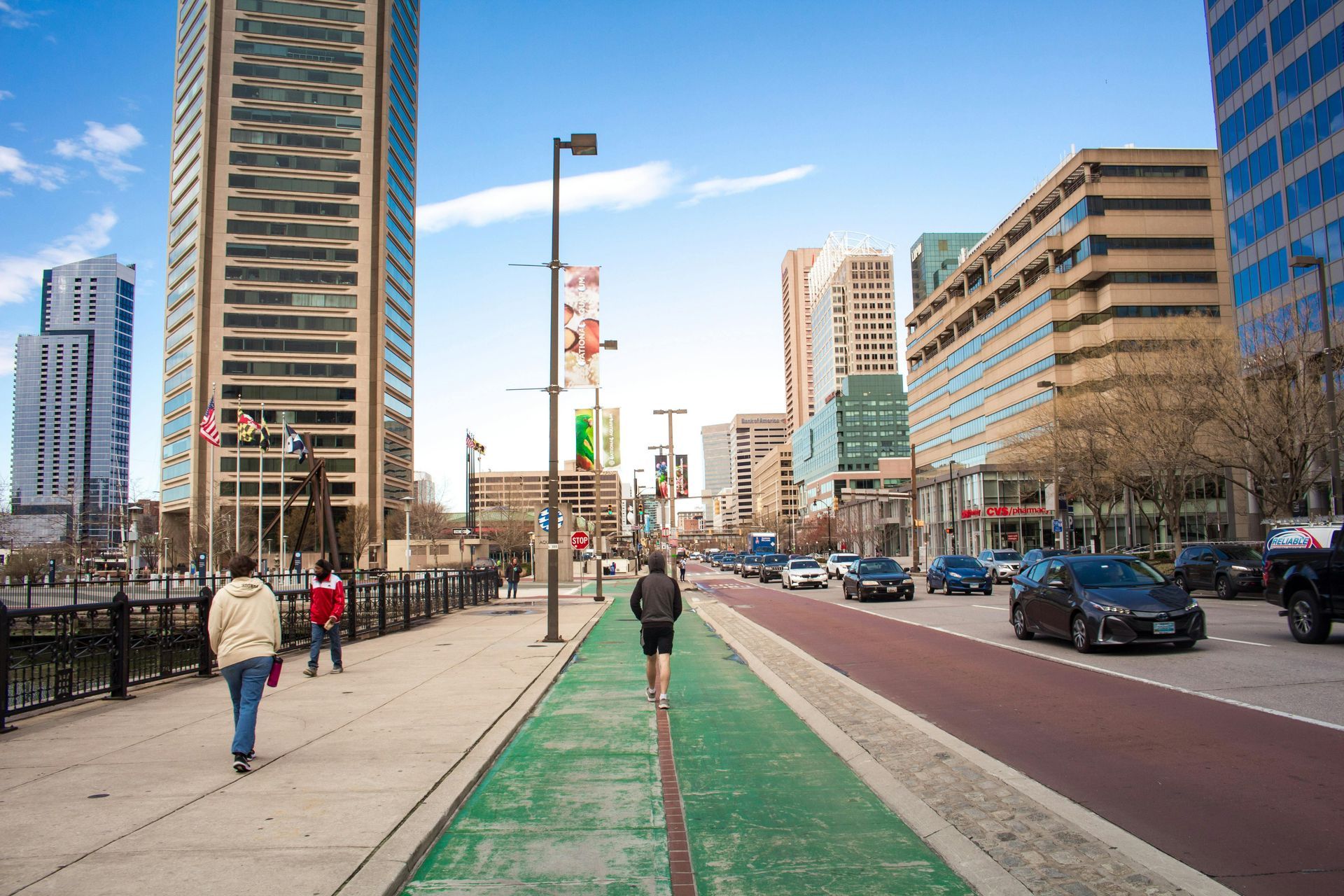 A group of people are walking down a sidewalk in a city.