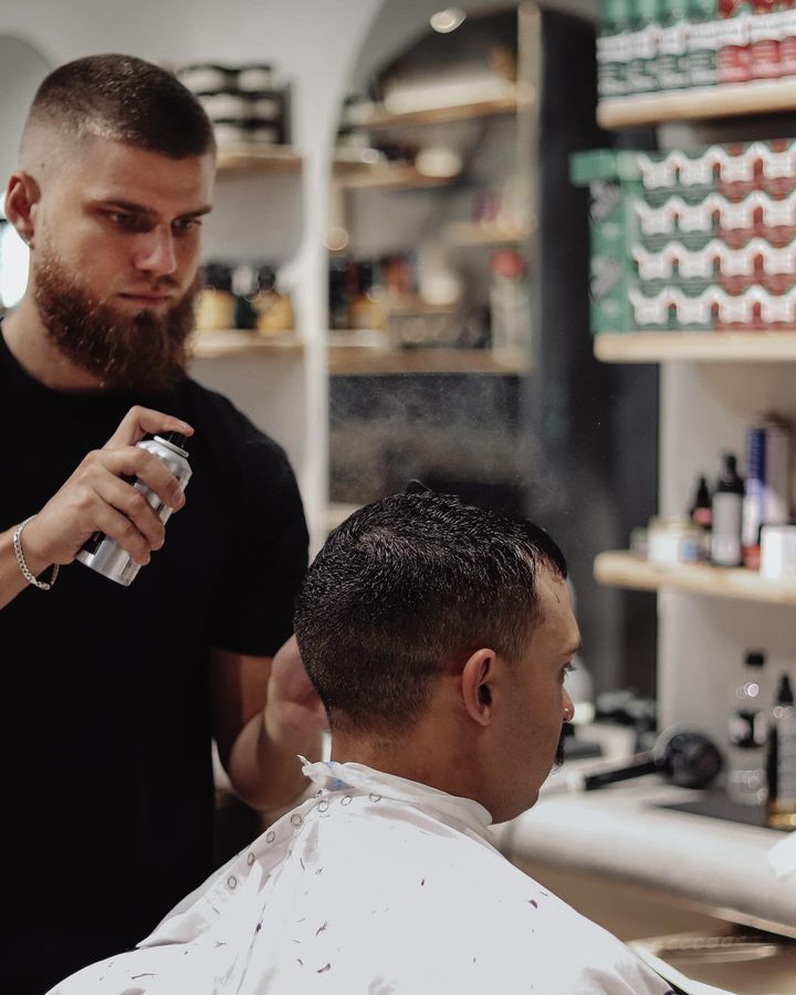 A Barber Spraying Water on a Man's Hair — Barber Bros & Co - Southport in Southport, QLD