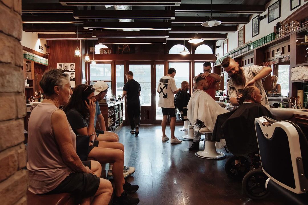 A Group of People Are Waiting in a Barber Shop Getting Their Hair Cut — Barber Bros & Co - Southport in Southport, QLD