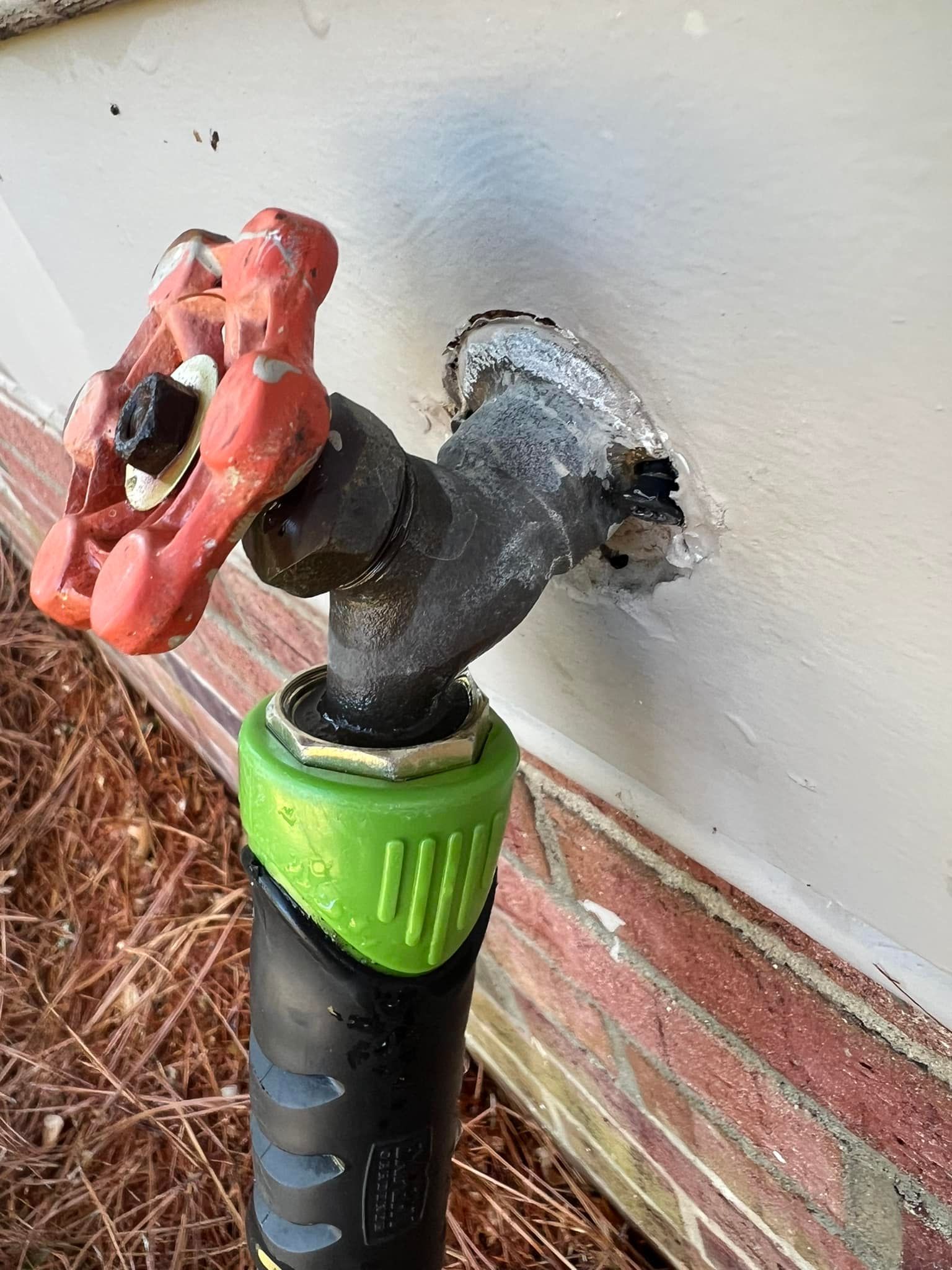 A close up of a water faucet on a brick wall.
