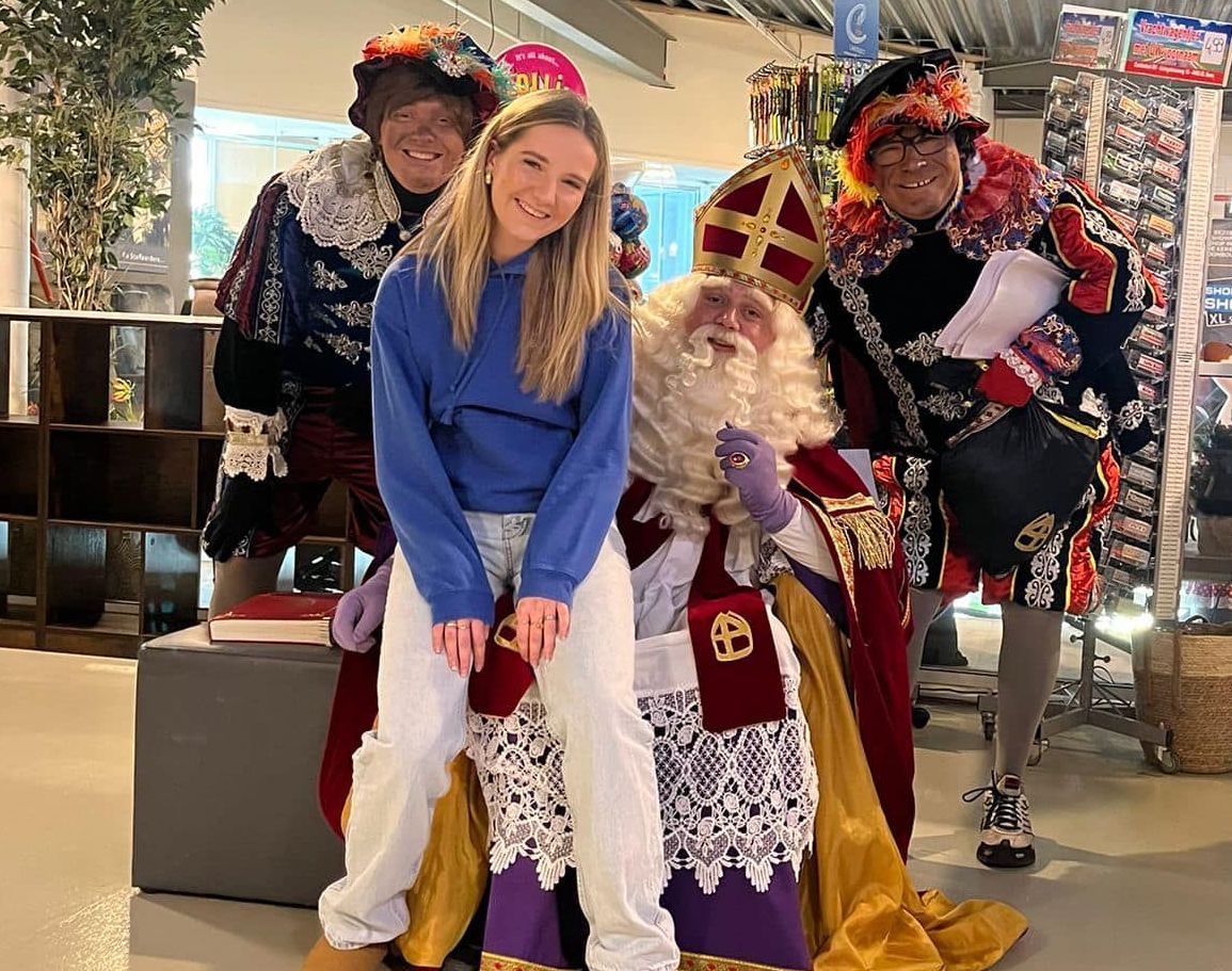 Een groep mensen poseert voor een foto met de Kerstman.