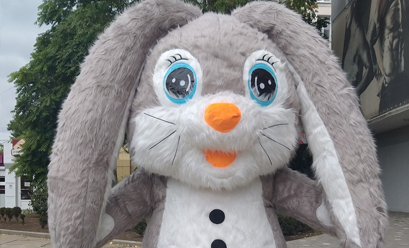 Een mascotte in de vorm van een opgezette konijn staat voor een gebouw.