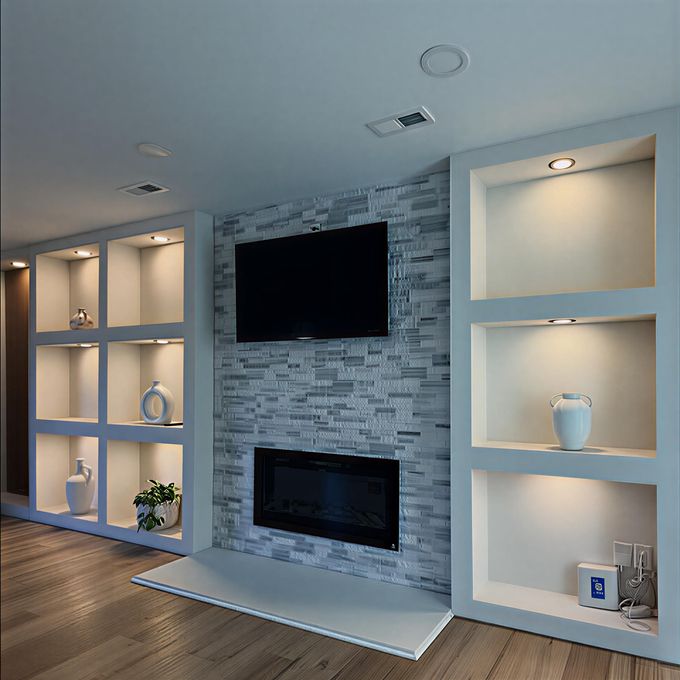 Built-in shelves flank a fireplace with TV; gray brick accent wall, recessed lighting, and white trim.
