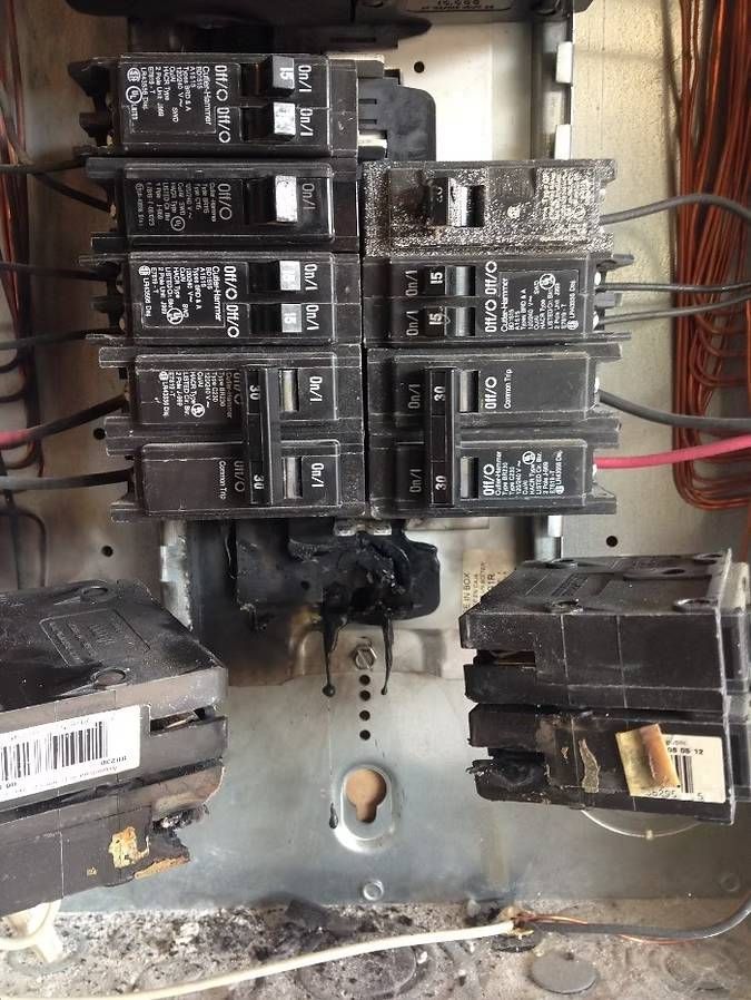 A close up of a electrical panel with a lot of wires coming out of it.