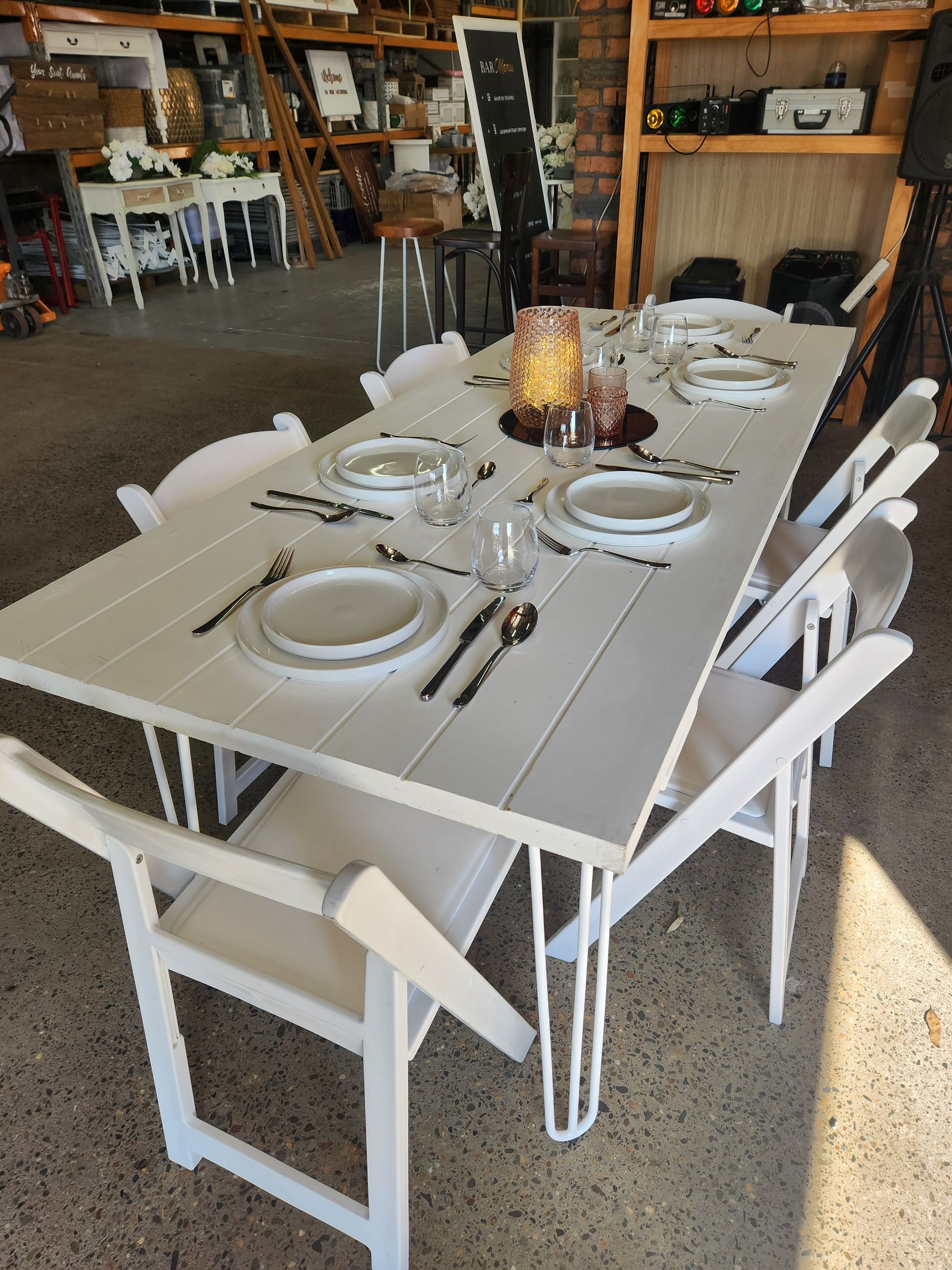 A White Table With White Chairs And Plates And Silverware On It — Red Shed Hire In Wauchope, NSW