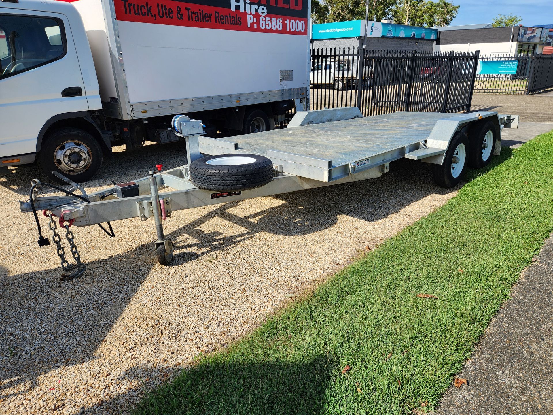 A Trailer Is Parked On The Side Of The Road Next To A Truck — Red Shed Hire In Wauchope, NSW