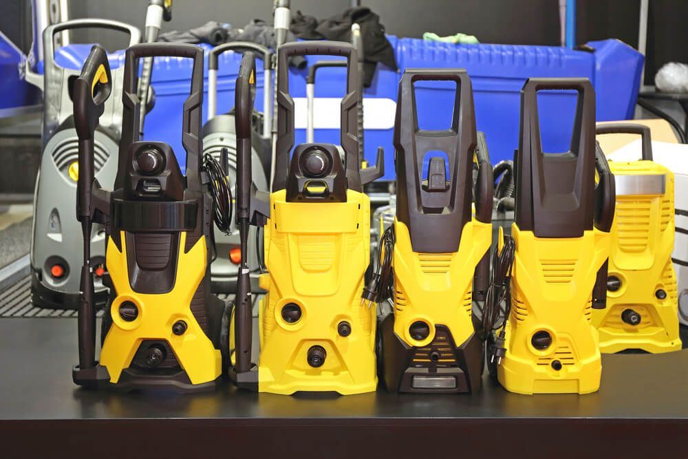 A Bunch Of High Pressure Washers Are Lined Up On A Table — Red Shed Hire In Wauchope, NSW