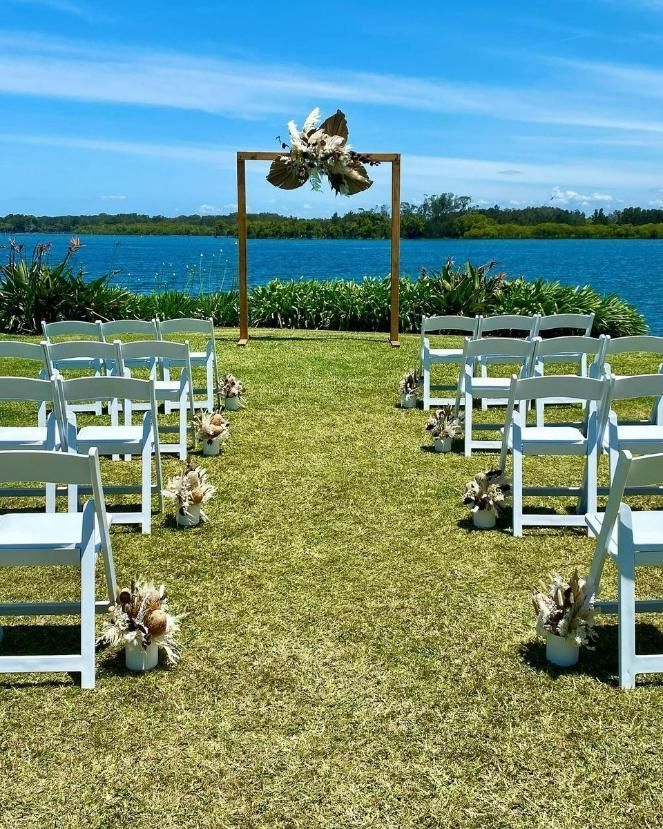 A Row Of White Chairs Are Lined Up In Front Of A Lake — Red Shed Hire In Wauchope, NSW