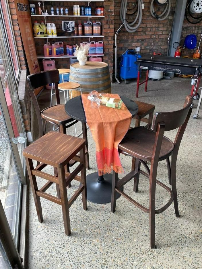 A Table And Chairs Are Sitting In A Garage Next To A Window — Red Shed Hire In Wauchope, NSW