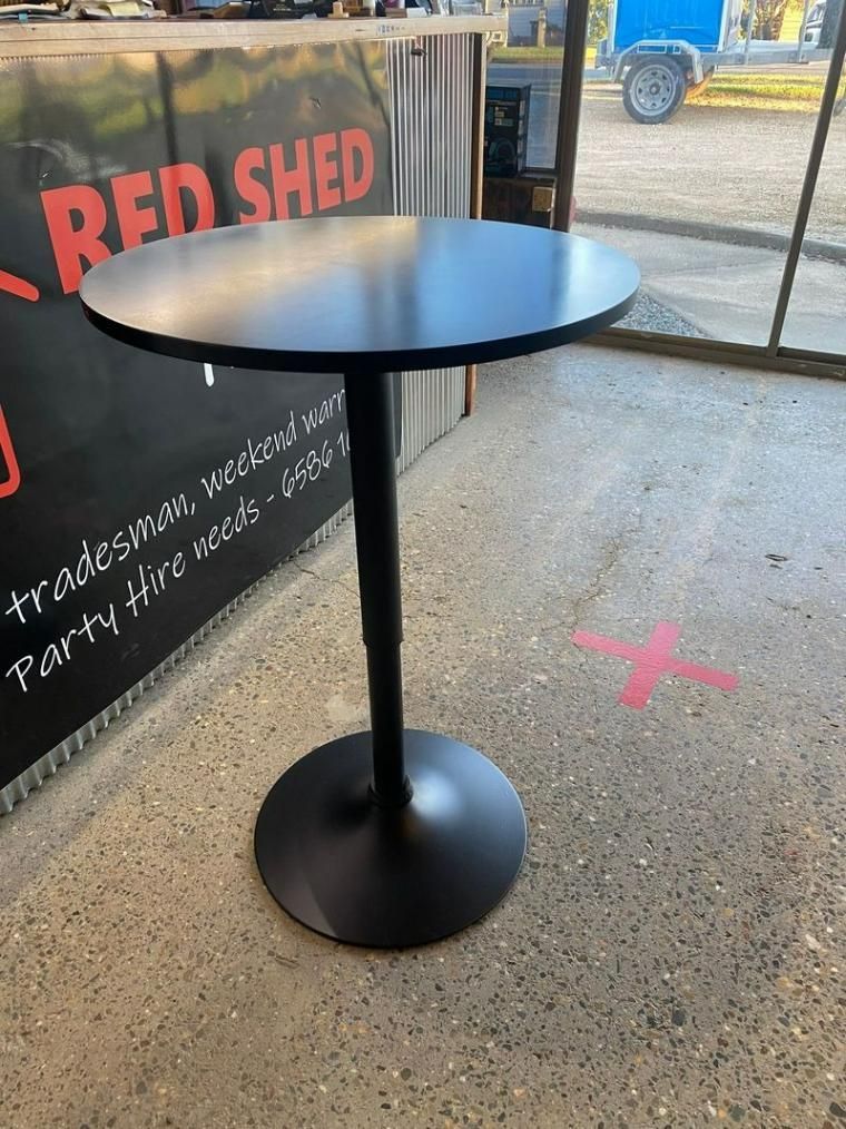 A Black Table Is Sitting In Front Of A Sign That Says Red Shed — Red Shed Hire In Wauchope, NSW