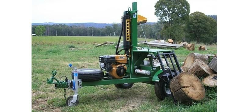 A Log Splitter Is Sitting On A Trailer In A Grassy Field — Red Shed Hire In Wauchope, NSW