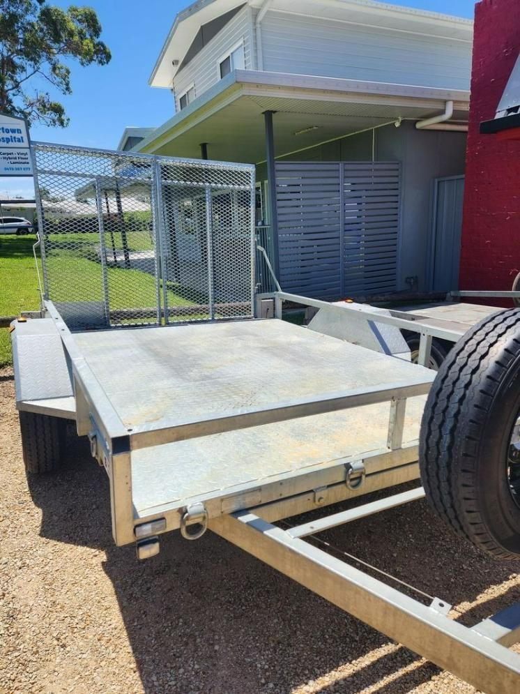 A Trailer With A Tire On It Is Parked In Front Of A House — Red Shed Hire In Wauchope, NSW