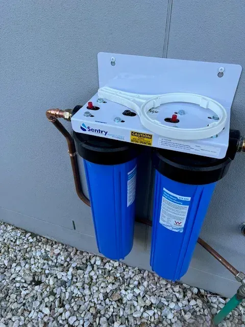 A Blue Water Filter is Attached to a Wall — Coastwide Plumbing Solutions in Sippy Downs, QLD