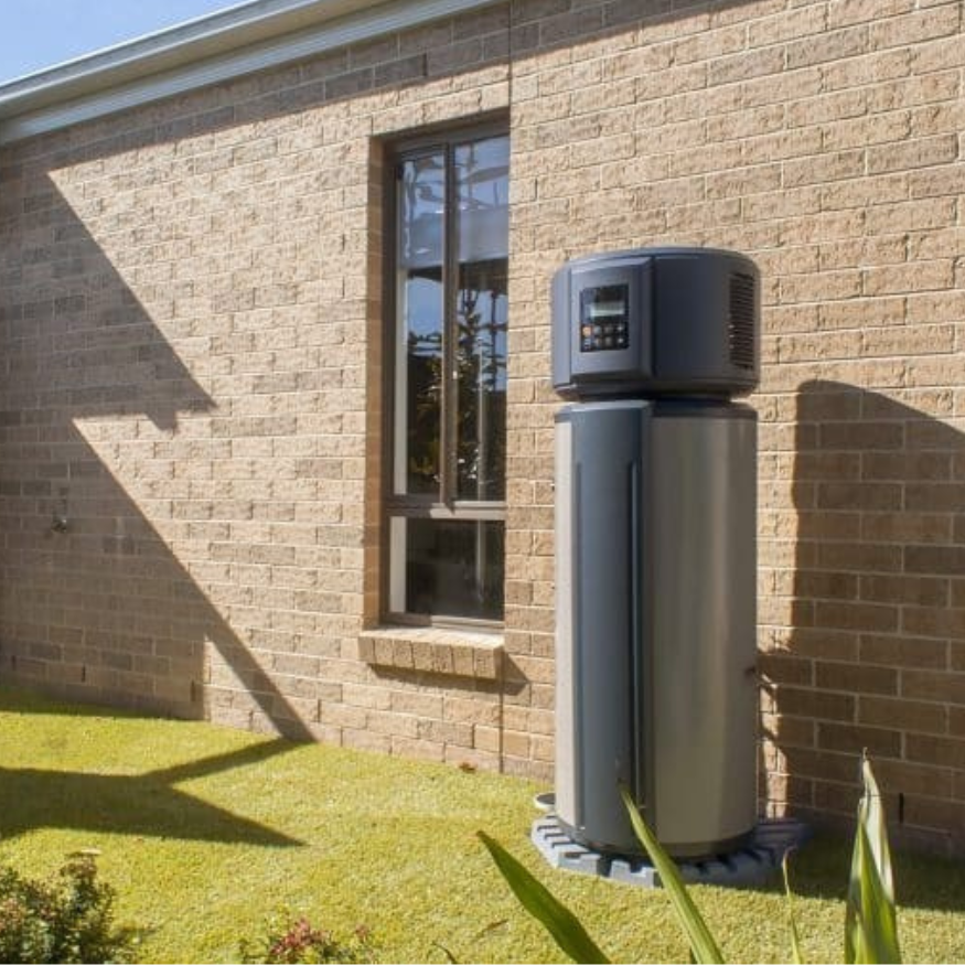 A Brick Building With a Large Water Heater in Front of It — Coastwide Plumbing Solutions in Sippy Downs, QLD