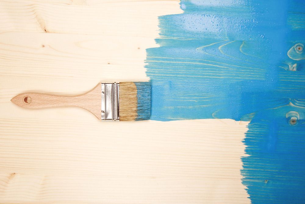 Painting Natural Wood With Paint Brush In Blue Color — Paint & Decor In Cloncurry QLD