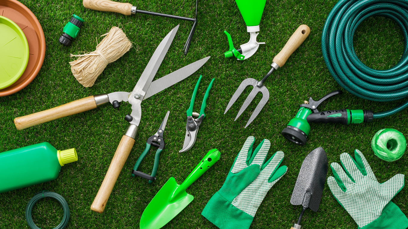 Green garden tools arranged on grass.