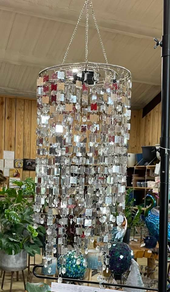 Silver, rectangular-mirrored wind chime hanging indoors, suspended from a chain.