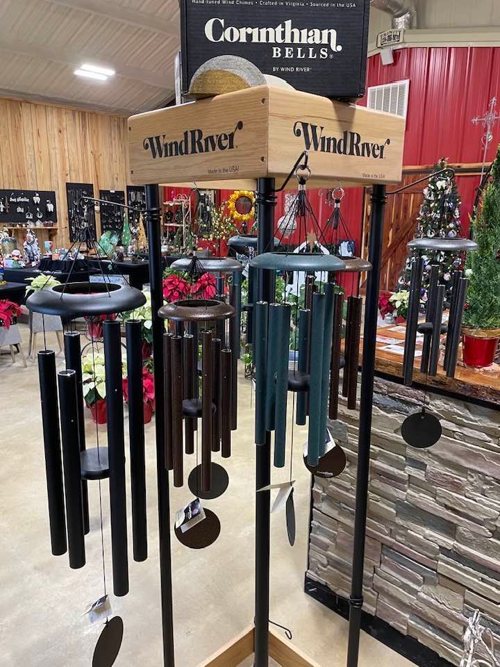 Display of Wind River wind chimes in a store, featuring various colors and sizes.