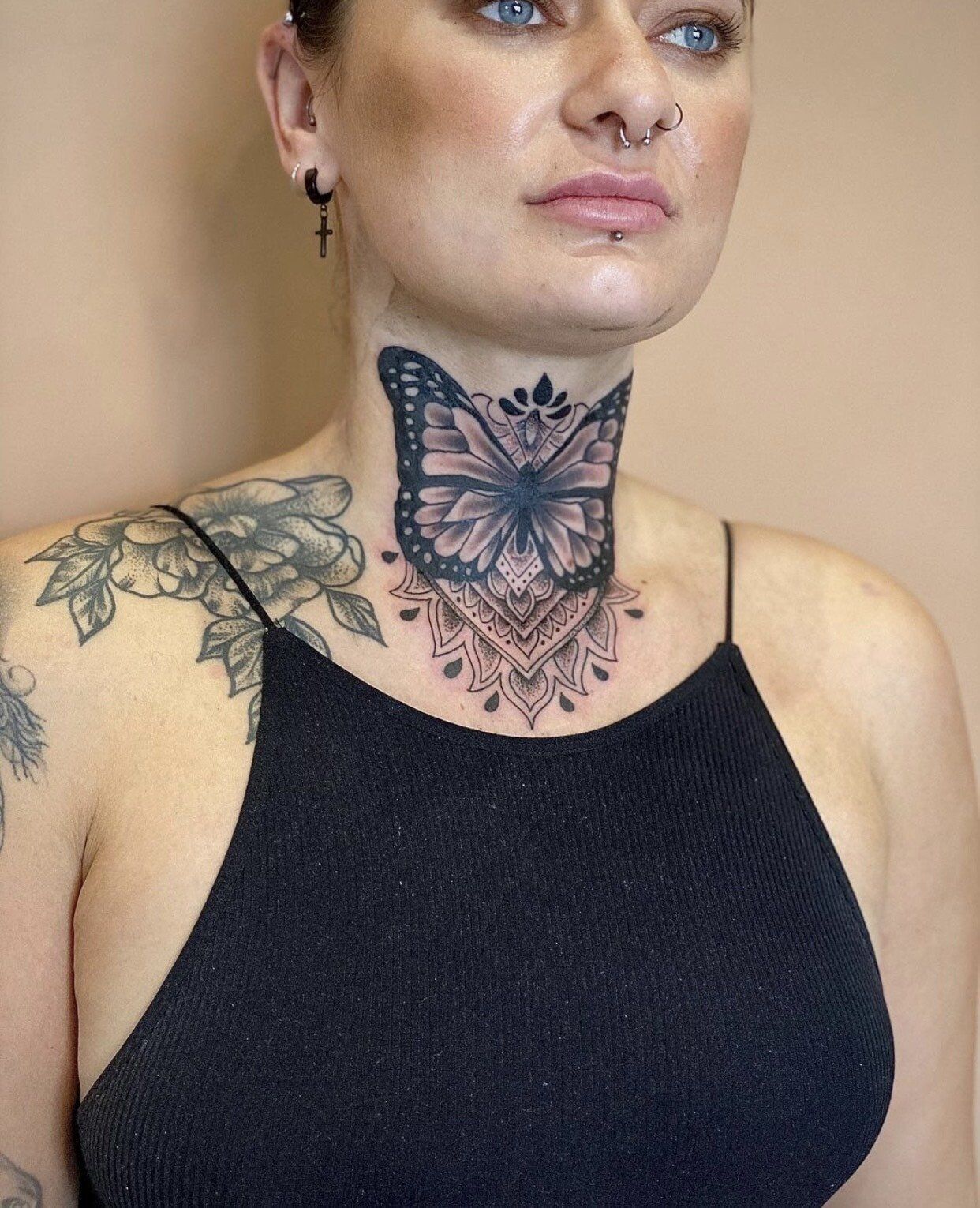 A woman with a butterfly tattoo on her neck.