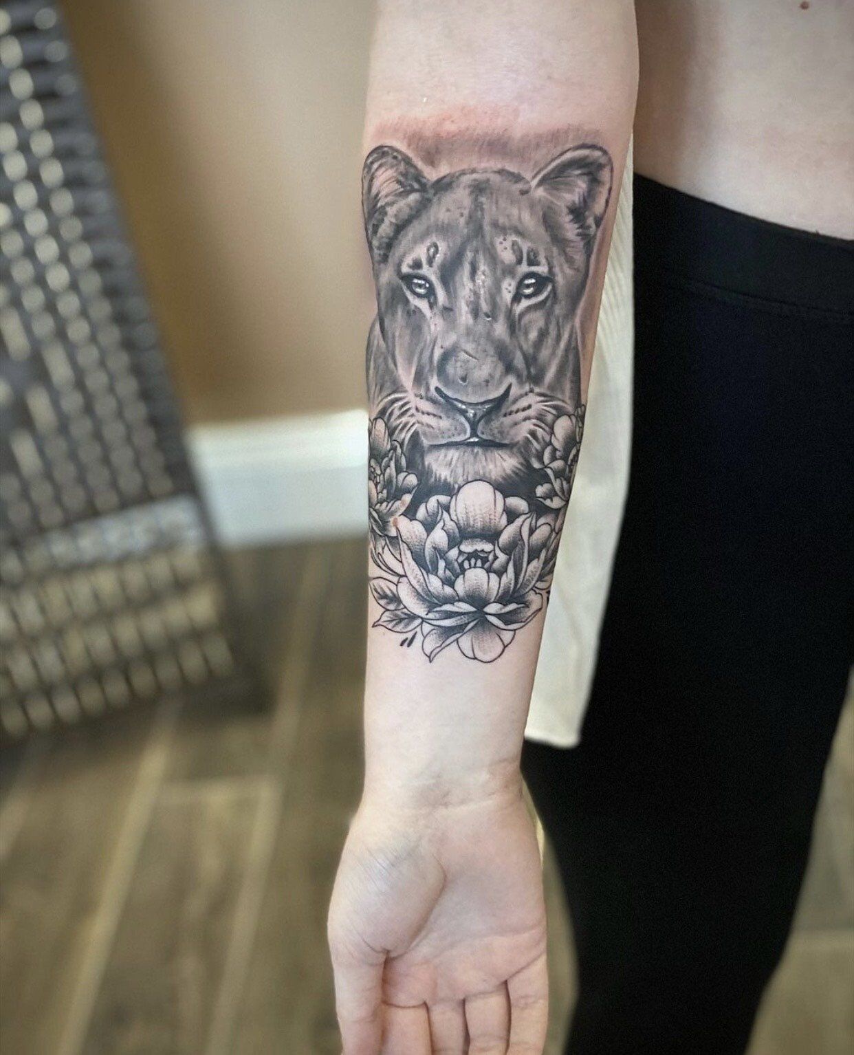 A woman has a tattoo of a lion on her forearm.