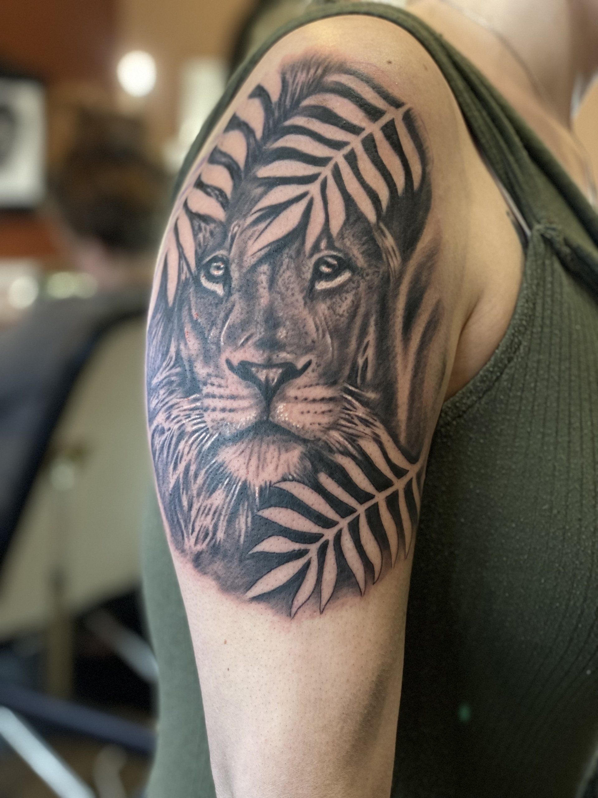 A woman has a tattoo of a lion on her shoulder