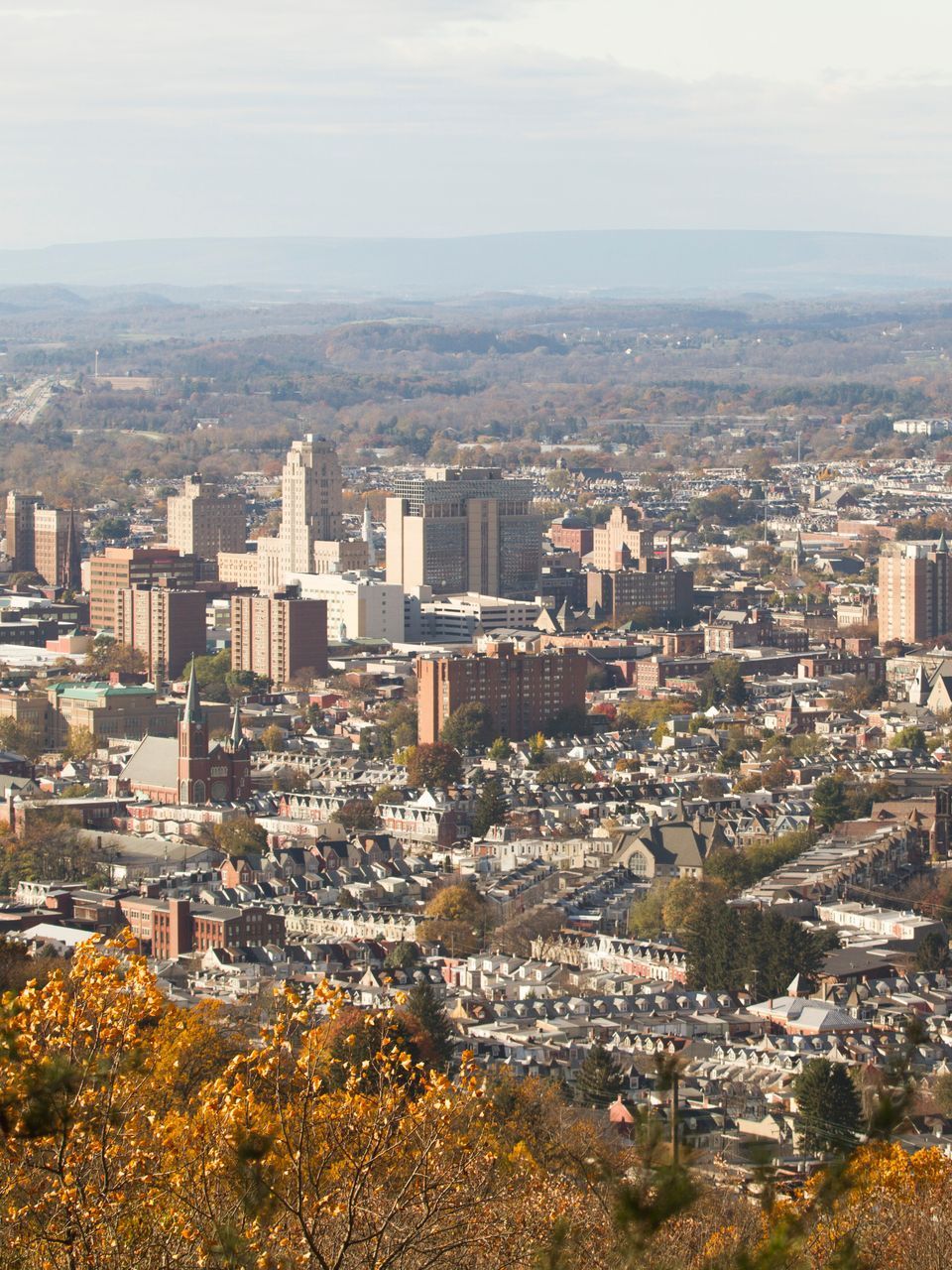A wooden walkway leading to a gazebo overlooking a body of water at sunset.
