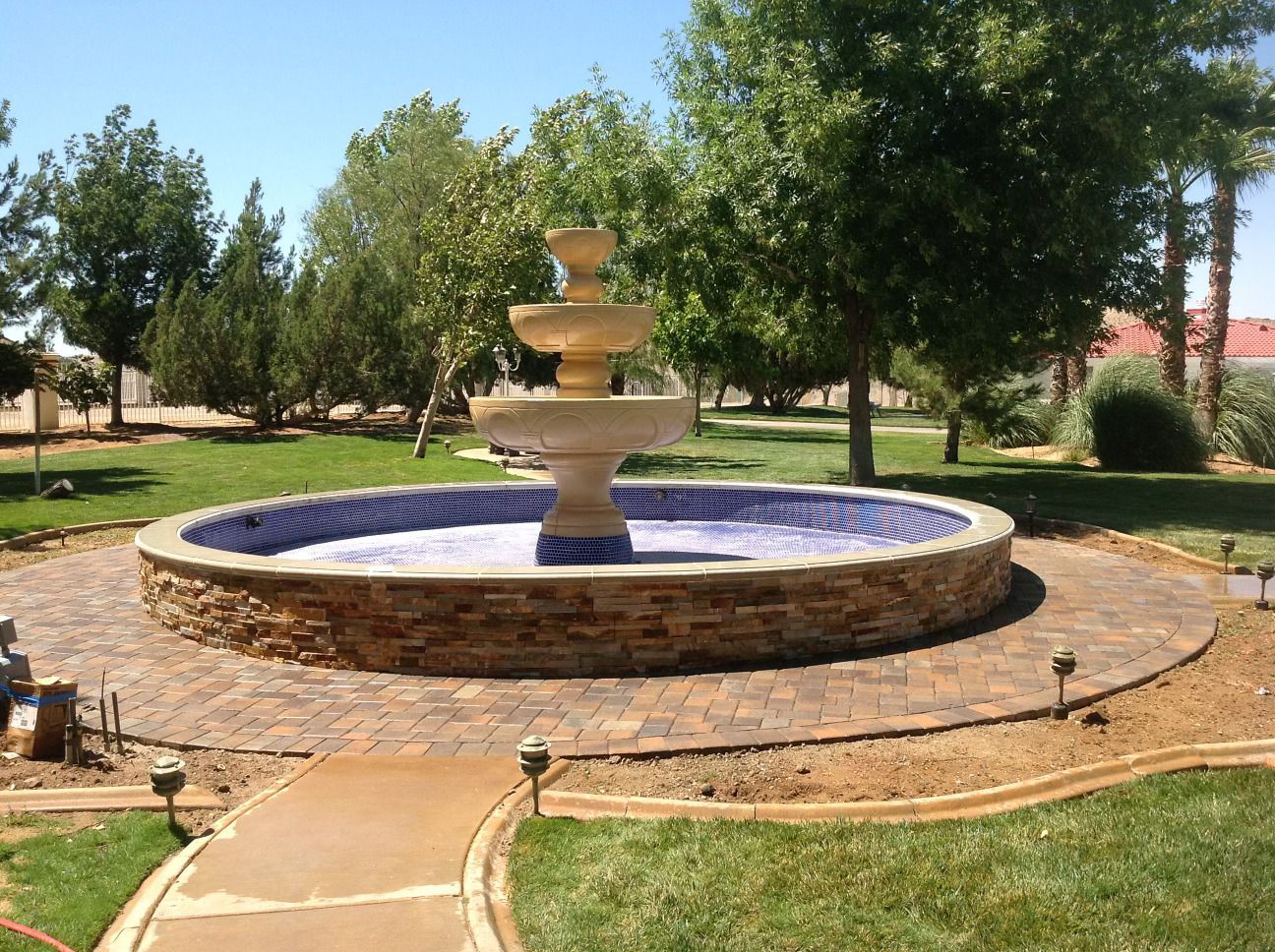 A large fountain in the middle of a lush green park