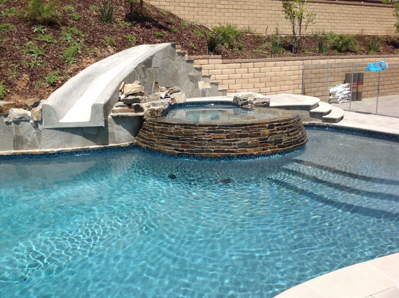 A large swimming pool with a slide and stairs