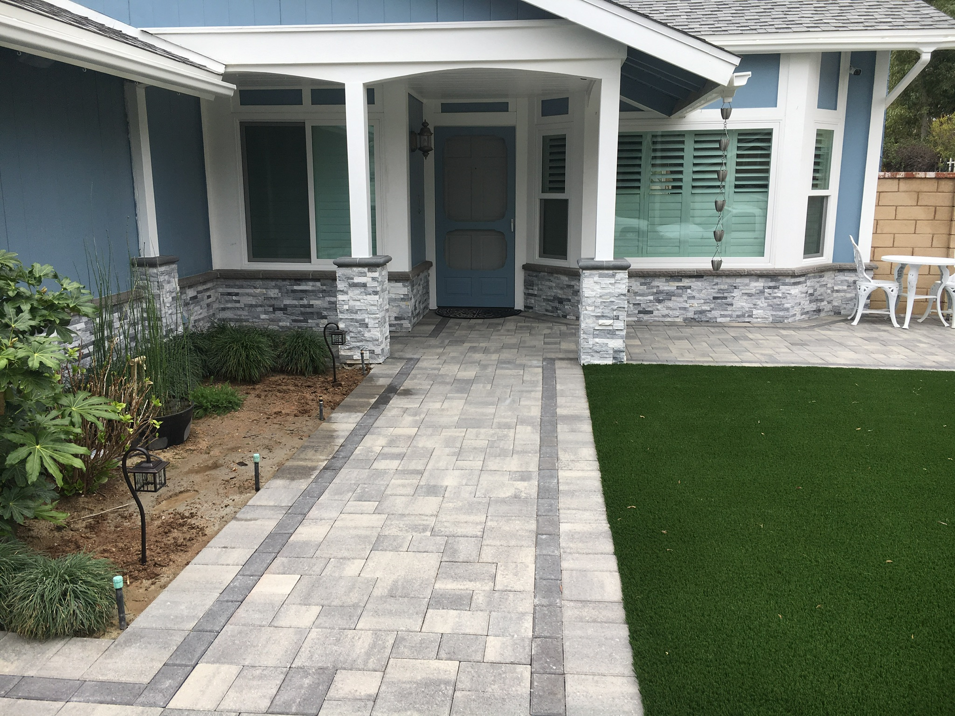 A brick walkway leading to the front door of a house