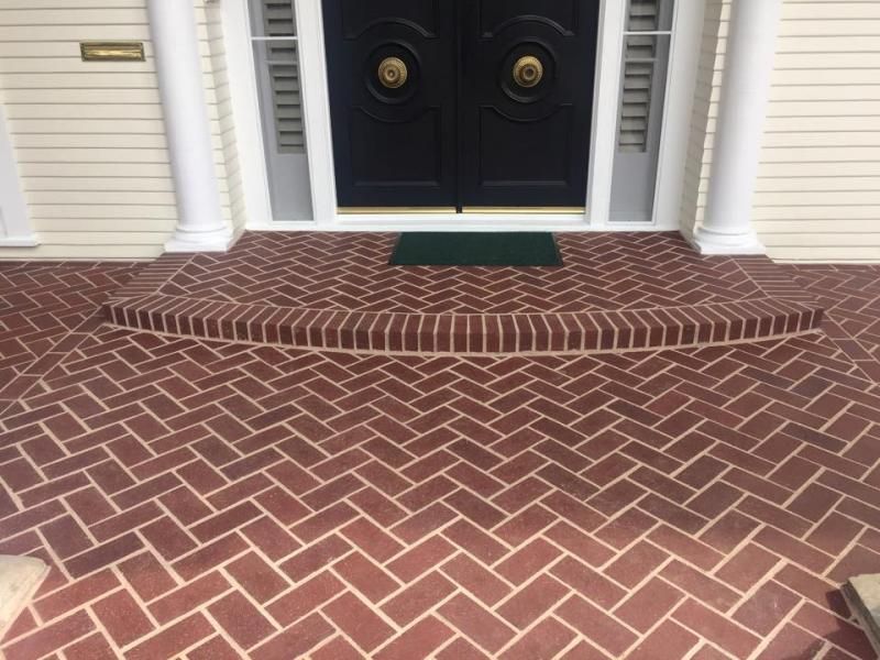A brick walkway leading to the front door of a house