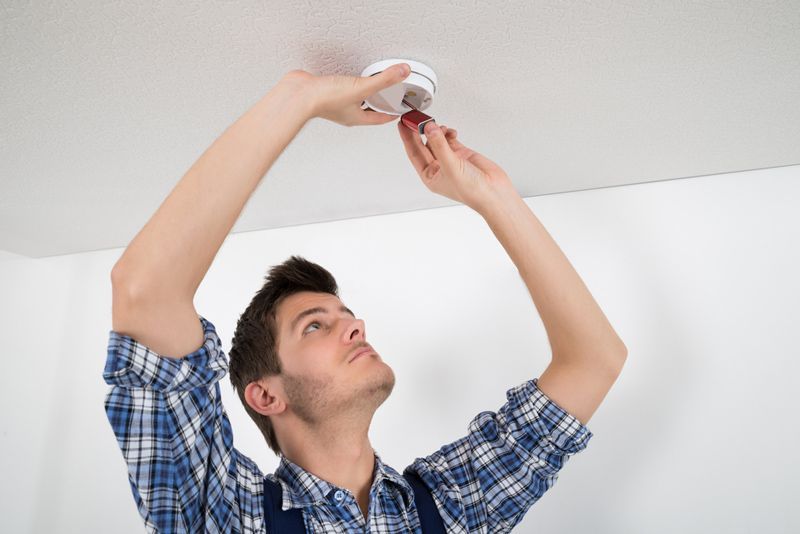 Guy Installing Smoke Detector — Fire Safety in Tamworth, NSW
