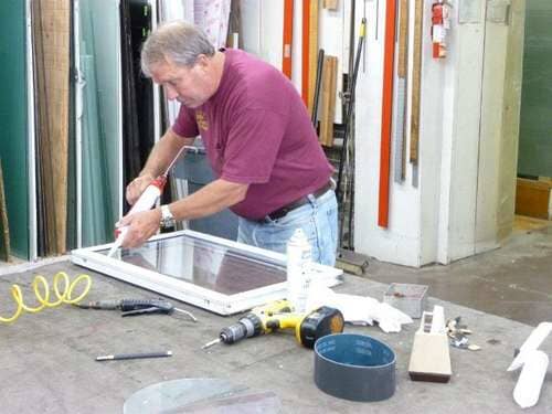 Man repairing window — Auto Glass Replacement & Repair in Troy, NY