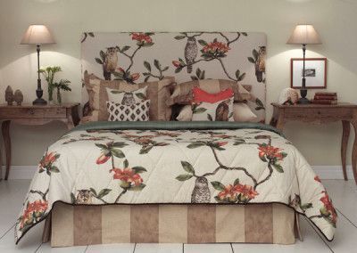 Bedroom with owl-themed bedspread, headboard, and pillows; brown, floral, beige, and orange. Side tables with lamps.