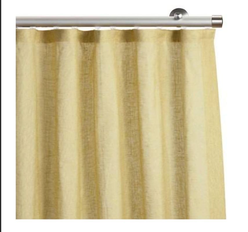 Yellow linen curtain hanging from a silver rod.