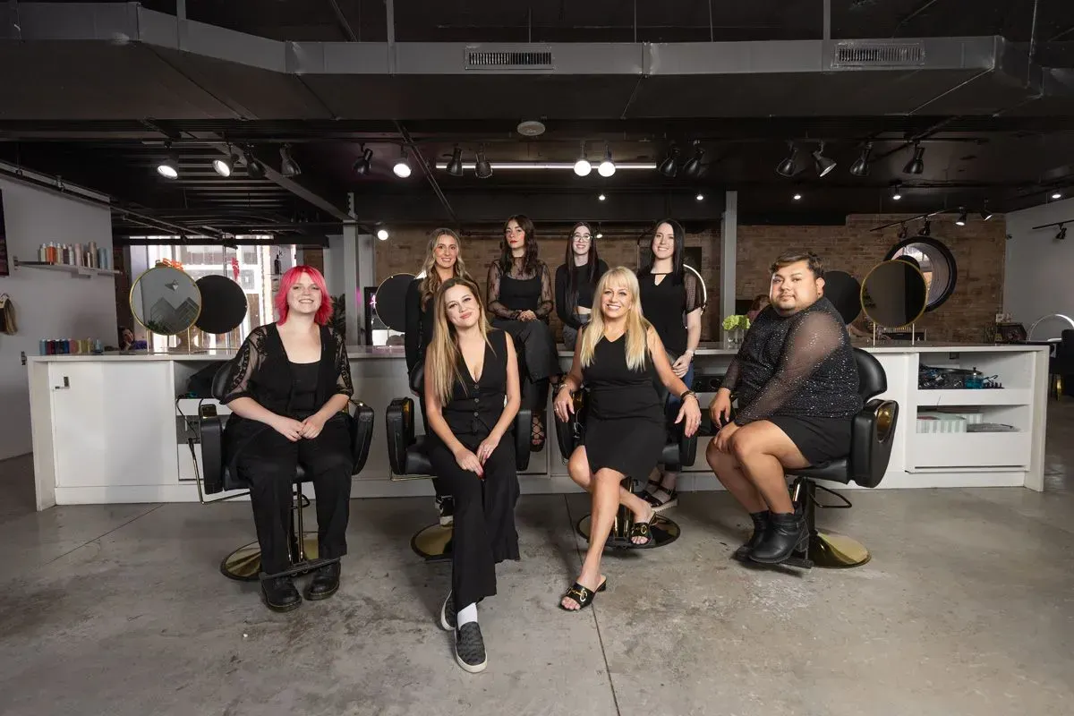 Five people seated in a modern studio, facing the camera with instruments and equipment in the background.