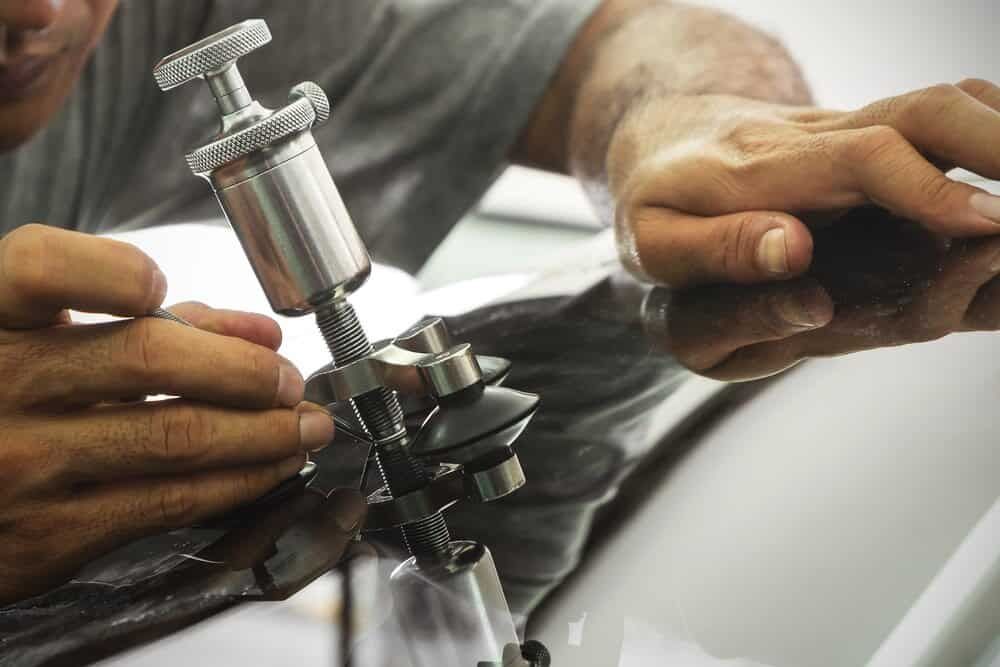 A Man is Repairing a Windshield With a Machine — Shepparton Radiators & Windscreens in Echuca, VIC