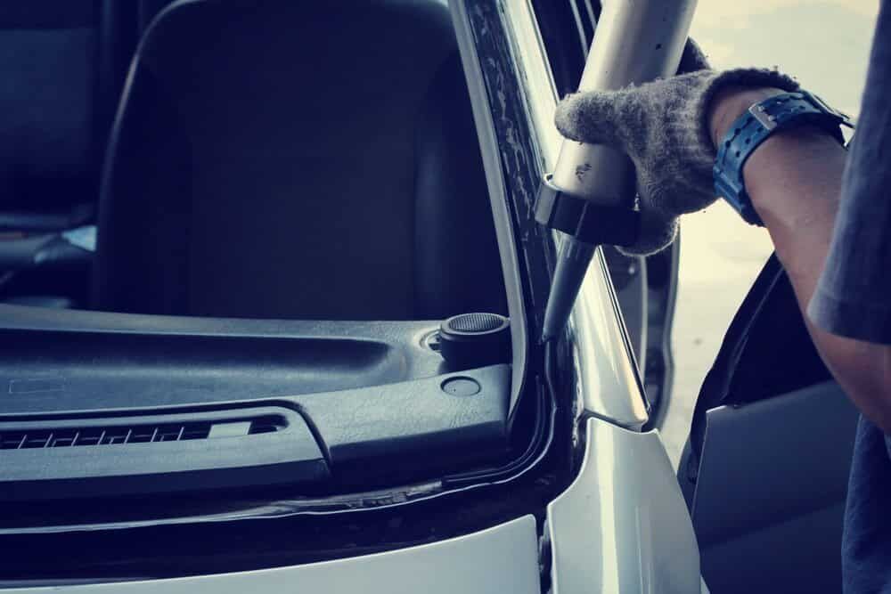 A Man is Installing a Windshield on a Car — Shepparton Radiators & Windscreens in Yarrawonga, VIC