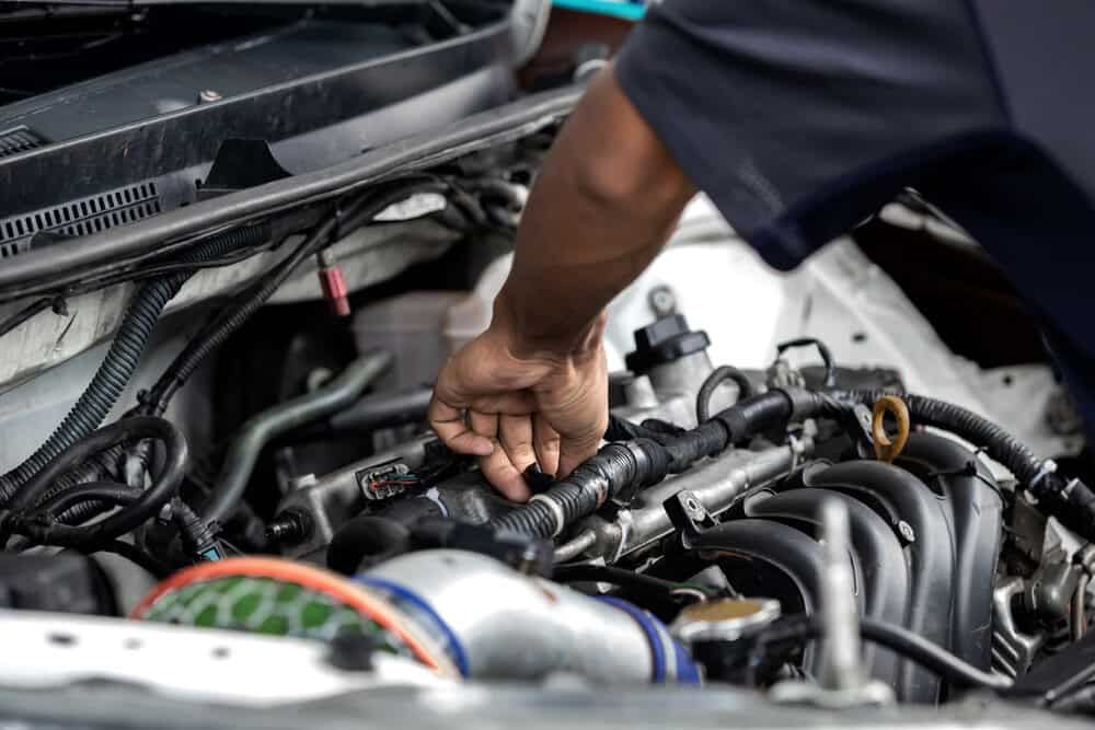 A Man is Working on the Engine of a Car — Shepparton Radiators & Windscreens in Cobram, VIC